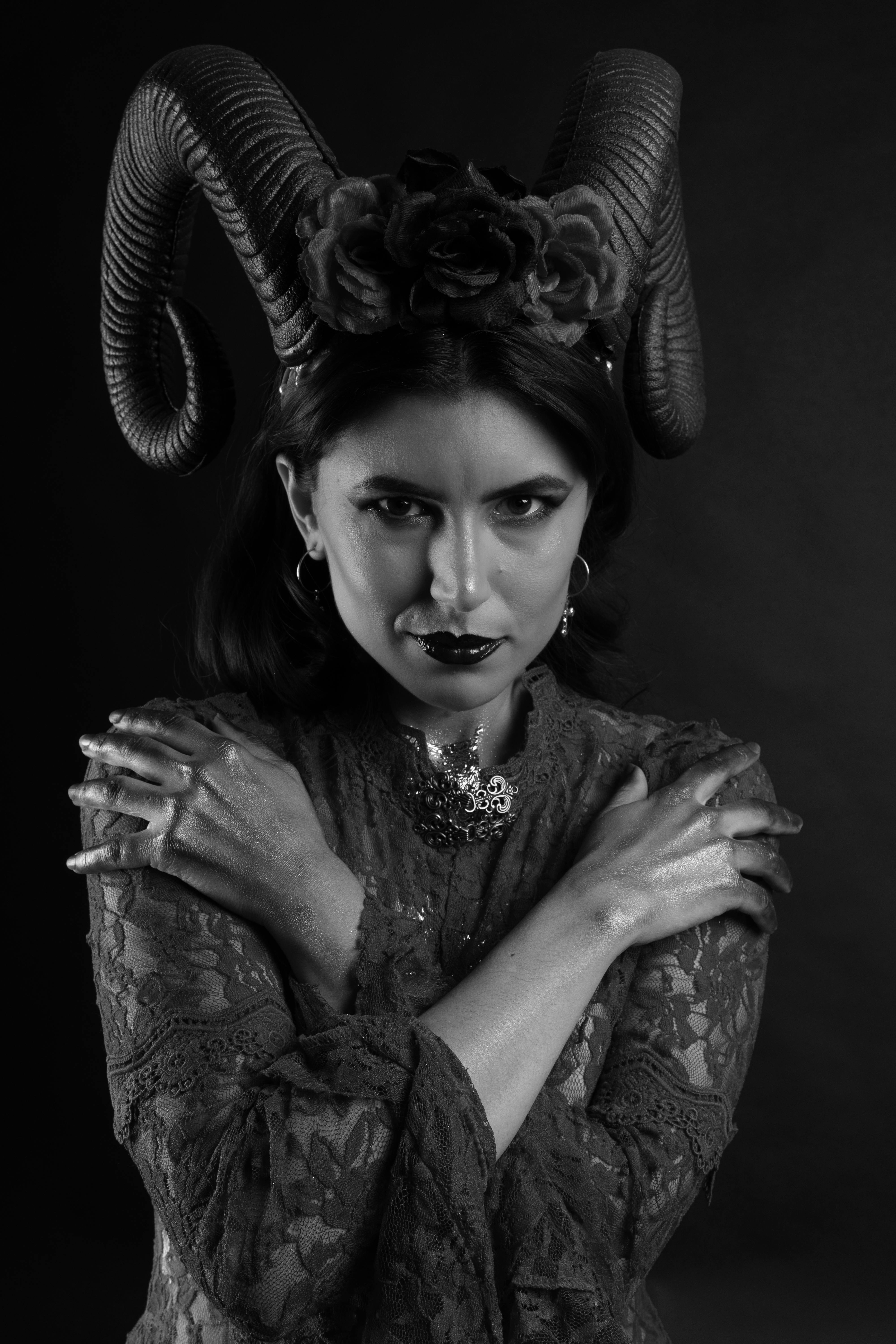 Gratuit Un portrait saisissant en noir et blanc d'une femme portant des cornes de bélier, exprimant une élégance sombre. Photos