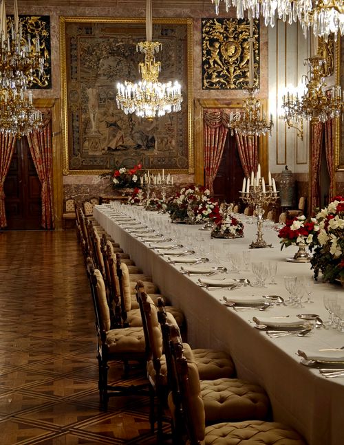 Free A lavishly decorated banquet hall featuring a long dining table adorned with floral arrangements and chandeliers. Stock Photo