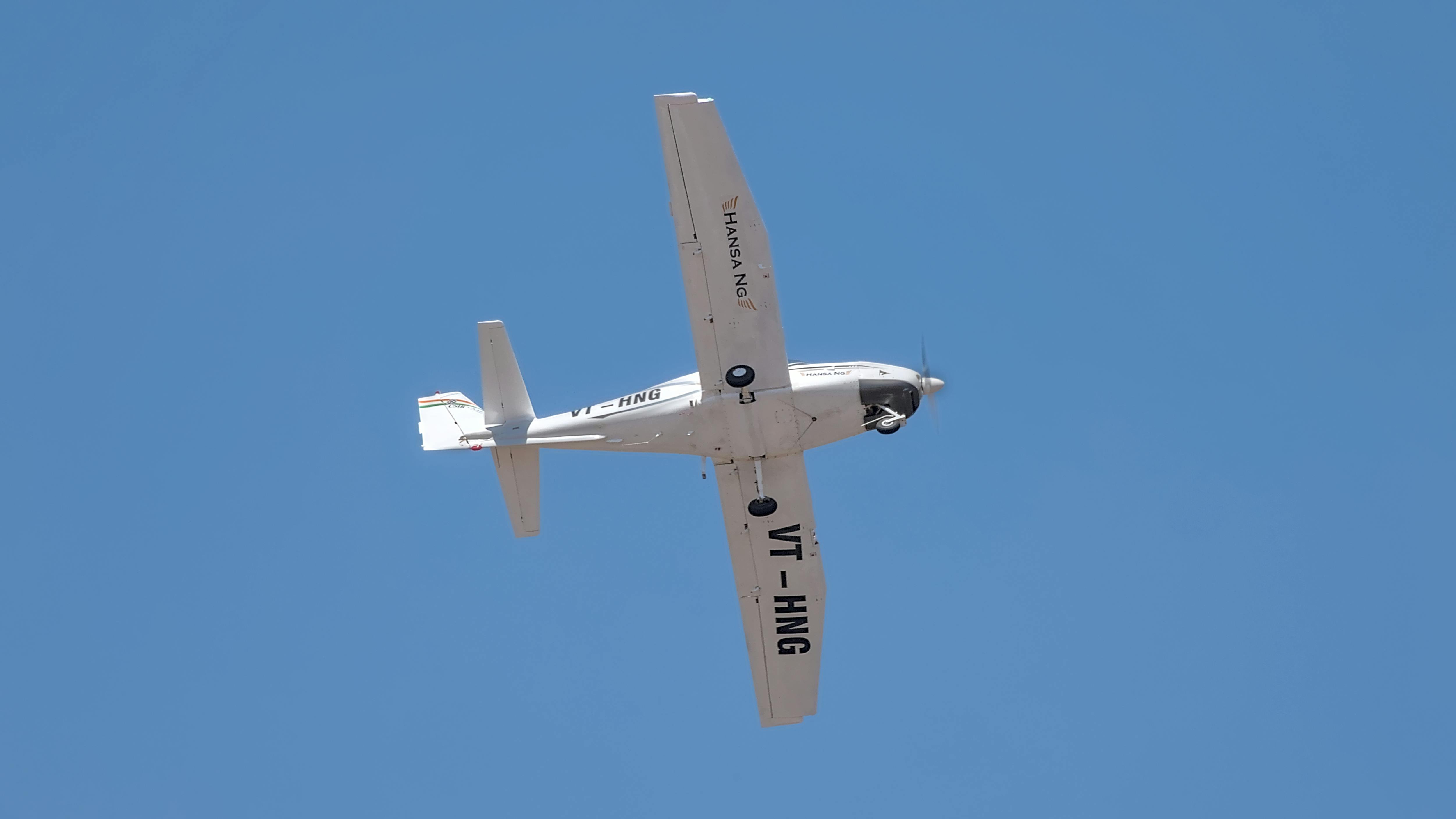 A light aircraft in flight featuring clear blue skies, captured in Bengaluru, India.