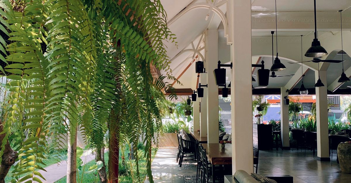 Peaceful outdoor restaurant setting in Cambodia with vibrant greenery.