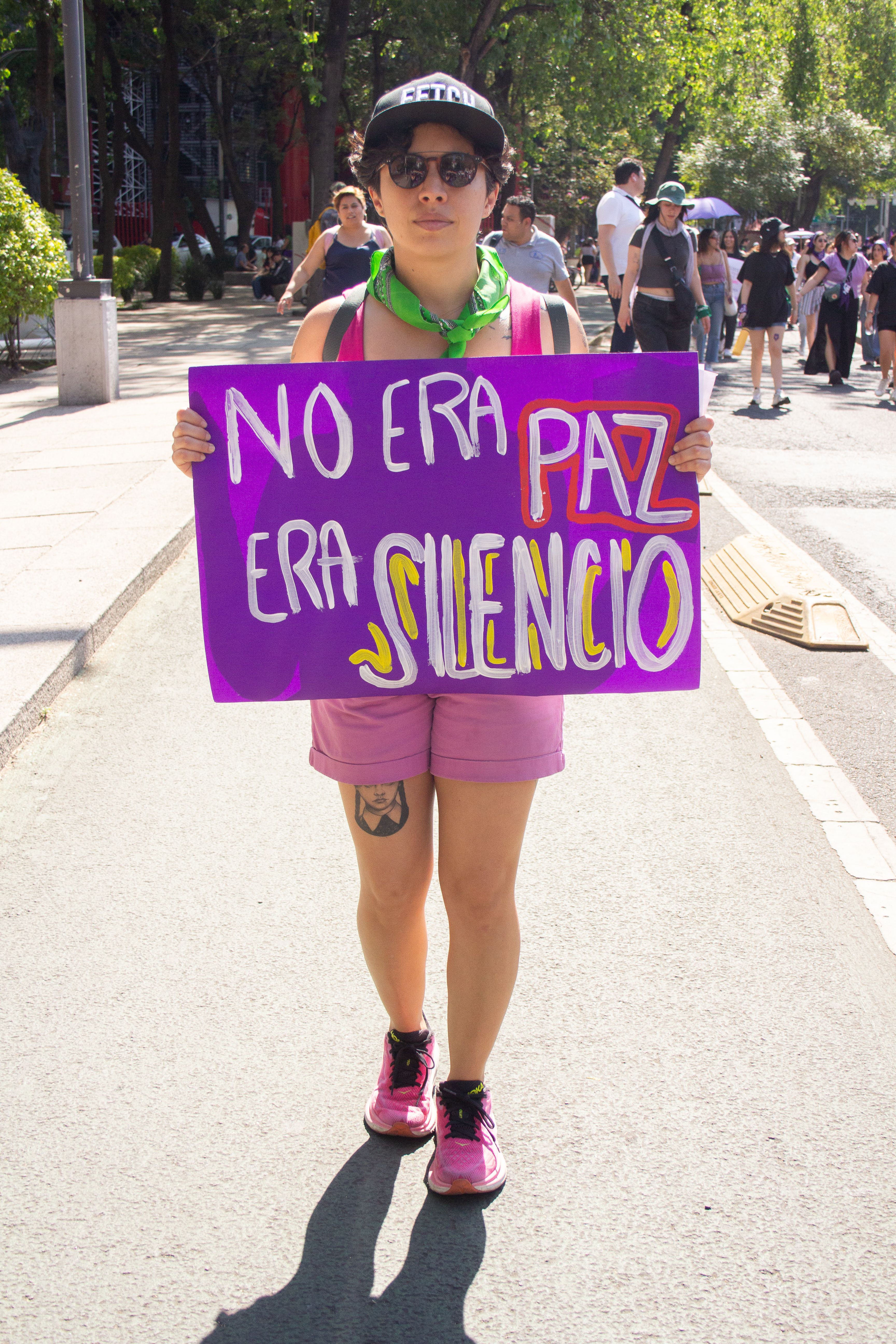 A person marches in Mexico City holding a bright feminist sign, advocating for women's rights.