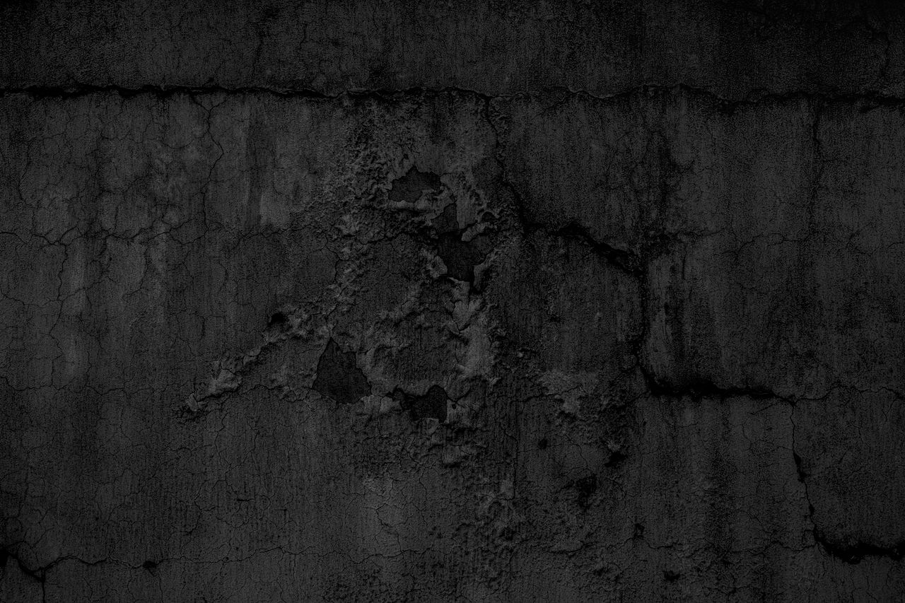 a textured close up of a dark grunge concrete wall perfect for backgro