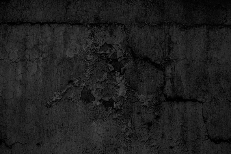 Close-up of a cracked concrete wall showing structural damage