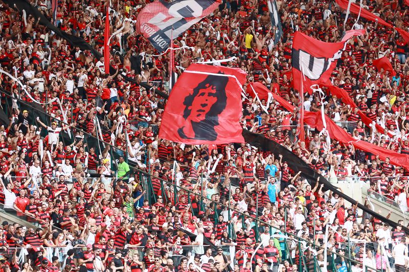 Supporters waving red flags in a derby crowd