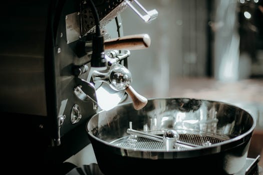 Close-up of a shiny industrial coffee roaster in a cafe setting, highlighting details.