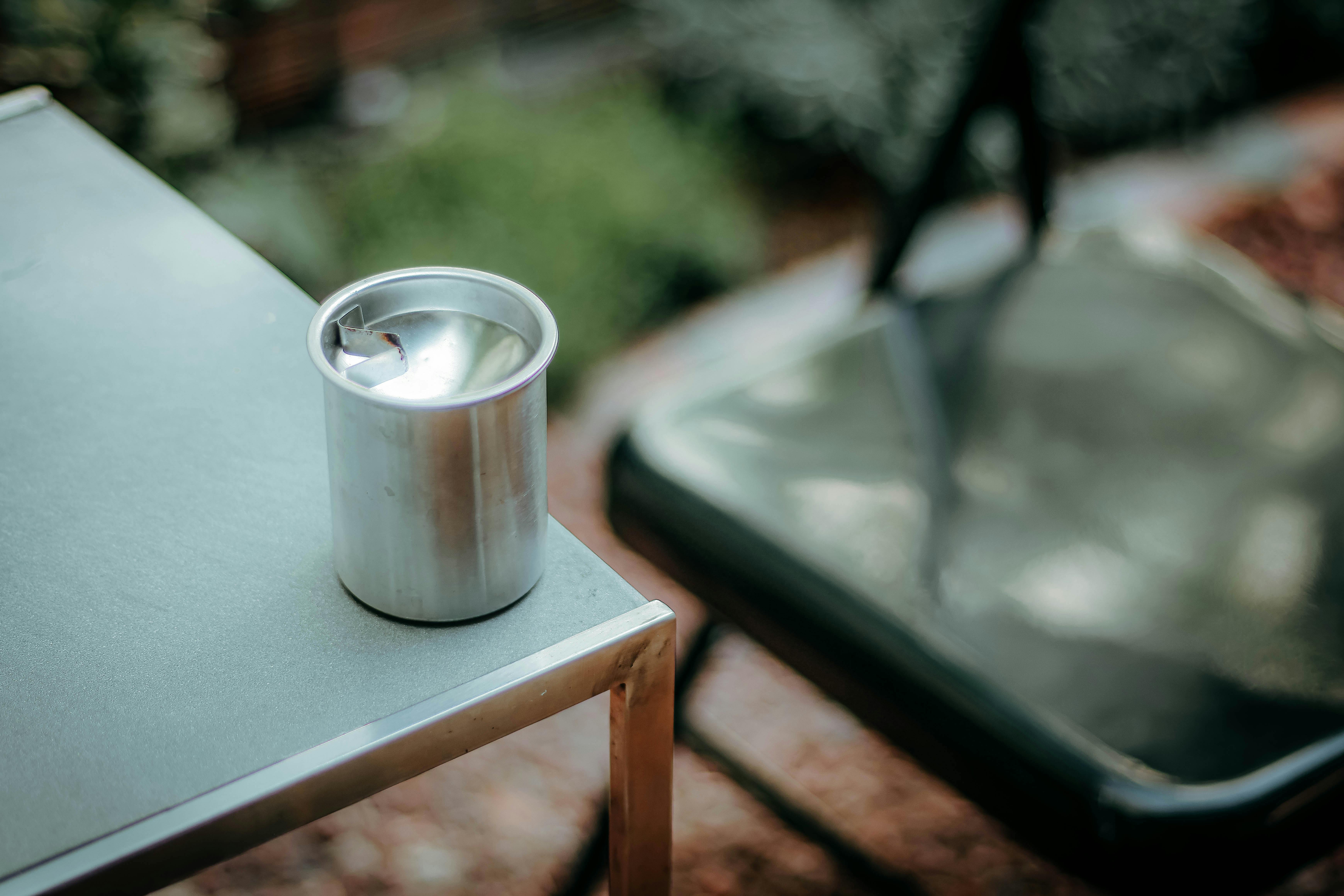 Free An outdoor setup featuring a silver metal can on a modern table. Stock Photo