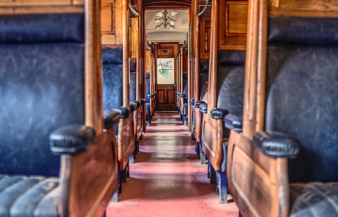 A vintage wooden train car interior with leather seats