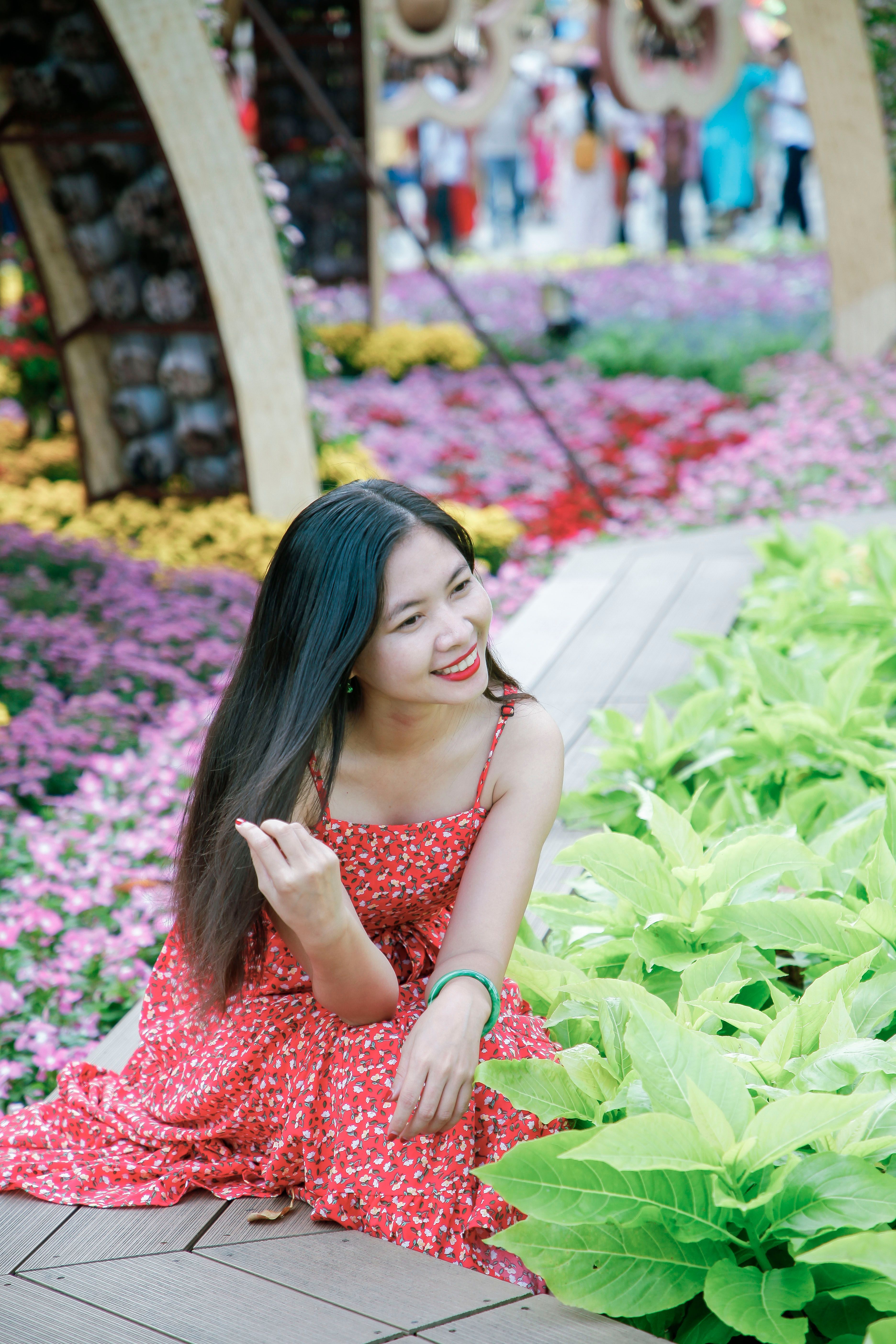 Young Woman in Red Dress Amidst Vibrant Floral Garden · Free Stock Photo