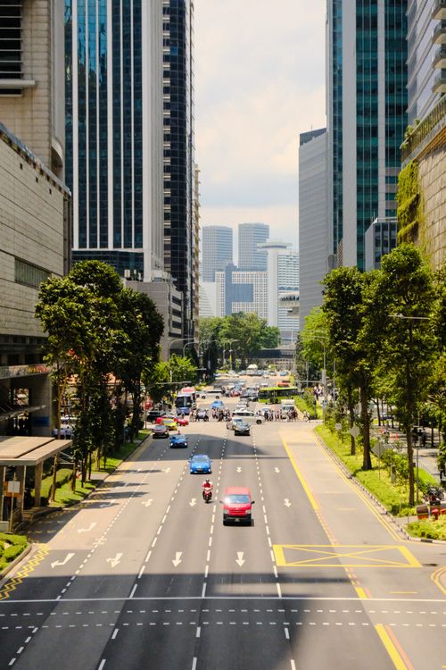 Free A busy city street lined with tall skyscrapers and heavy traffic on a sunny day. Stock Photo