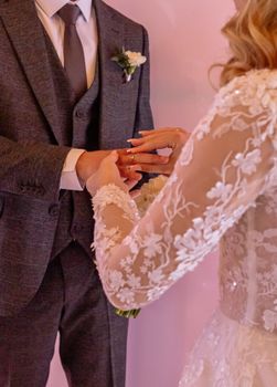 A beautiful moment of a bride and groom exchanging rings during a wedding ceremony.