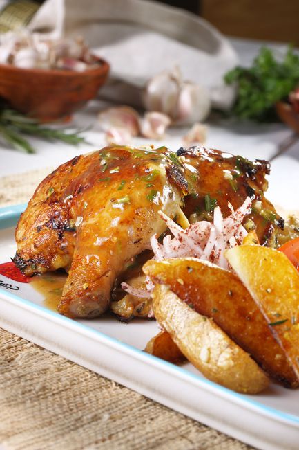 Golden-seared chicken thighs coated in a creamy garlic and mustard sauce, garnished with thyme, in a cast iron skillet.