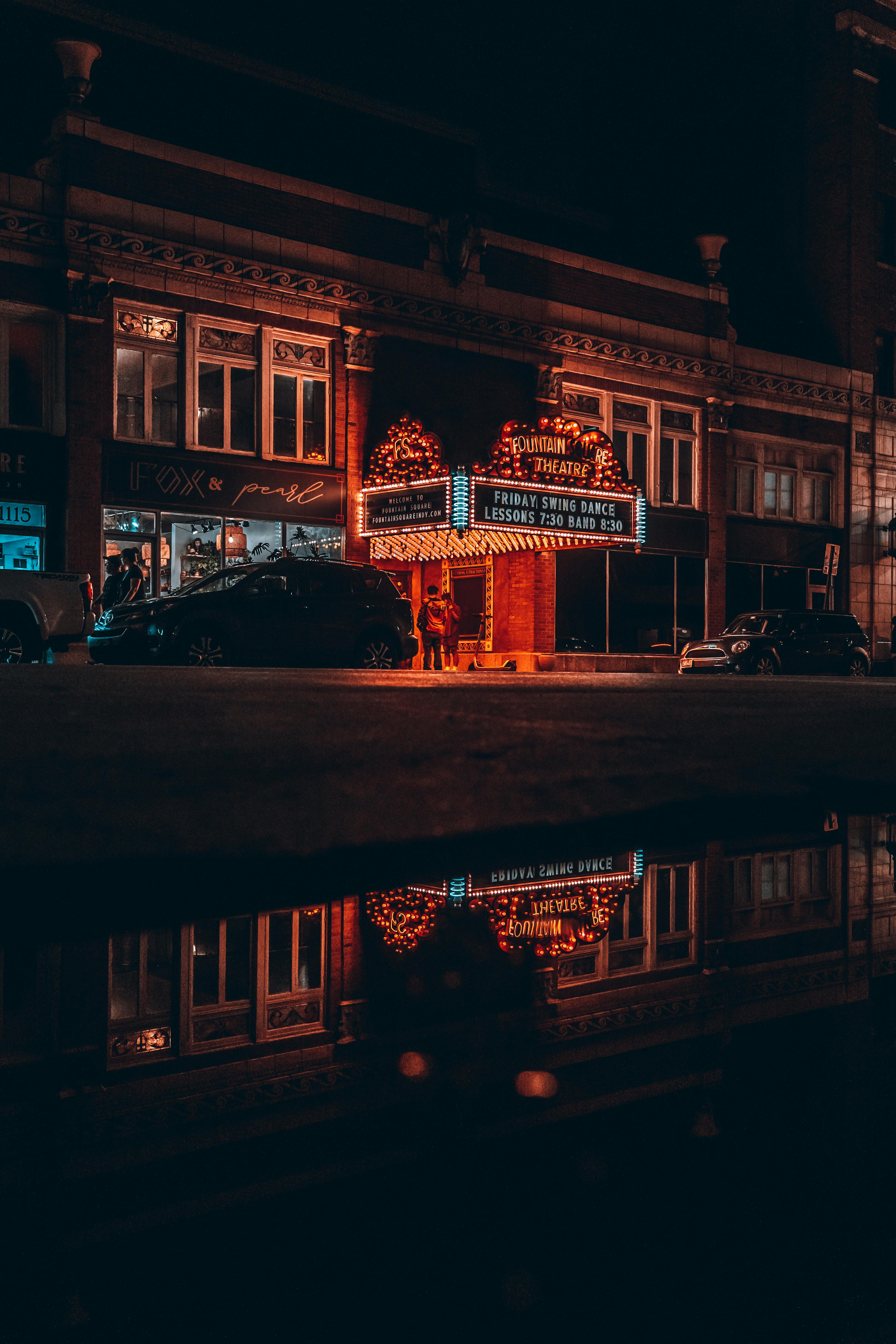 Ücretsiz Indianapolis şehir merkezindeki klasik bir tiyatro, büyüleyici bir gece manzarasında canlı neon yansımaları yakalıyor. Stok Fotoğraflar
