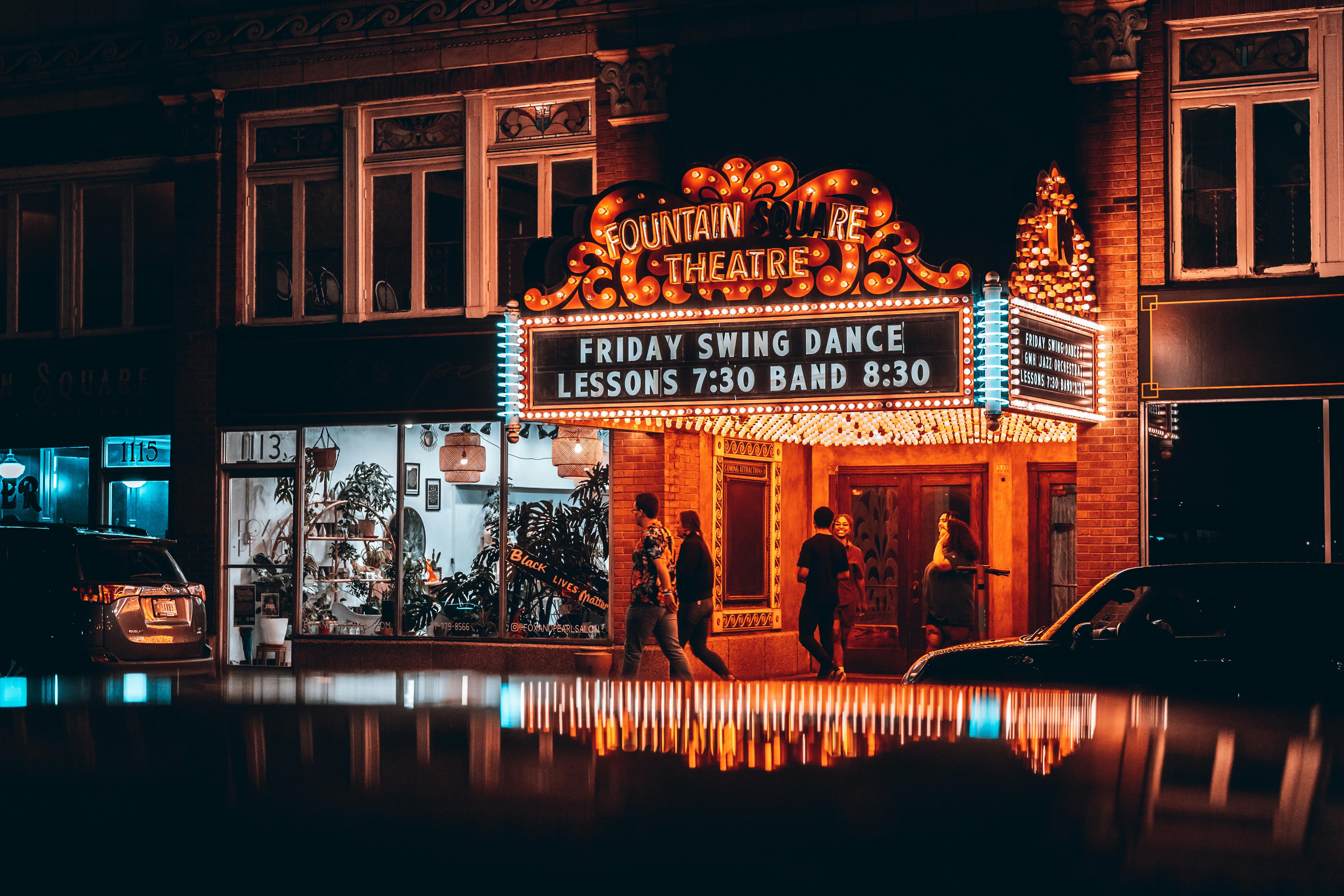 Gratis Pemandangan malam yang semarak di Fountain Square Theatre di Indianapolis dengan lampu neon dan pantulan. Foto Stok