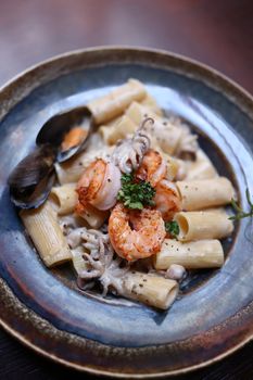Delicious seafood pasta featuring shrimp, squid, and clams on a rustic plate.