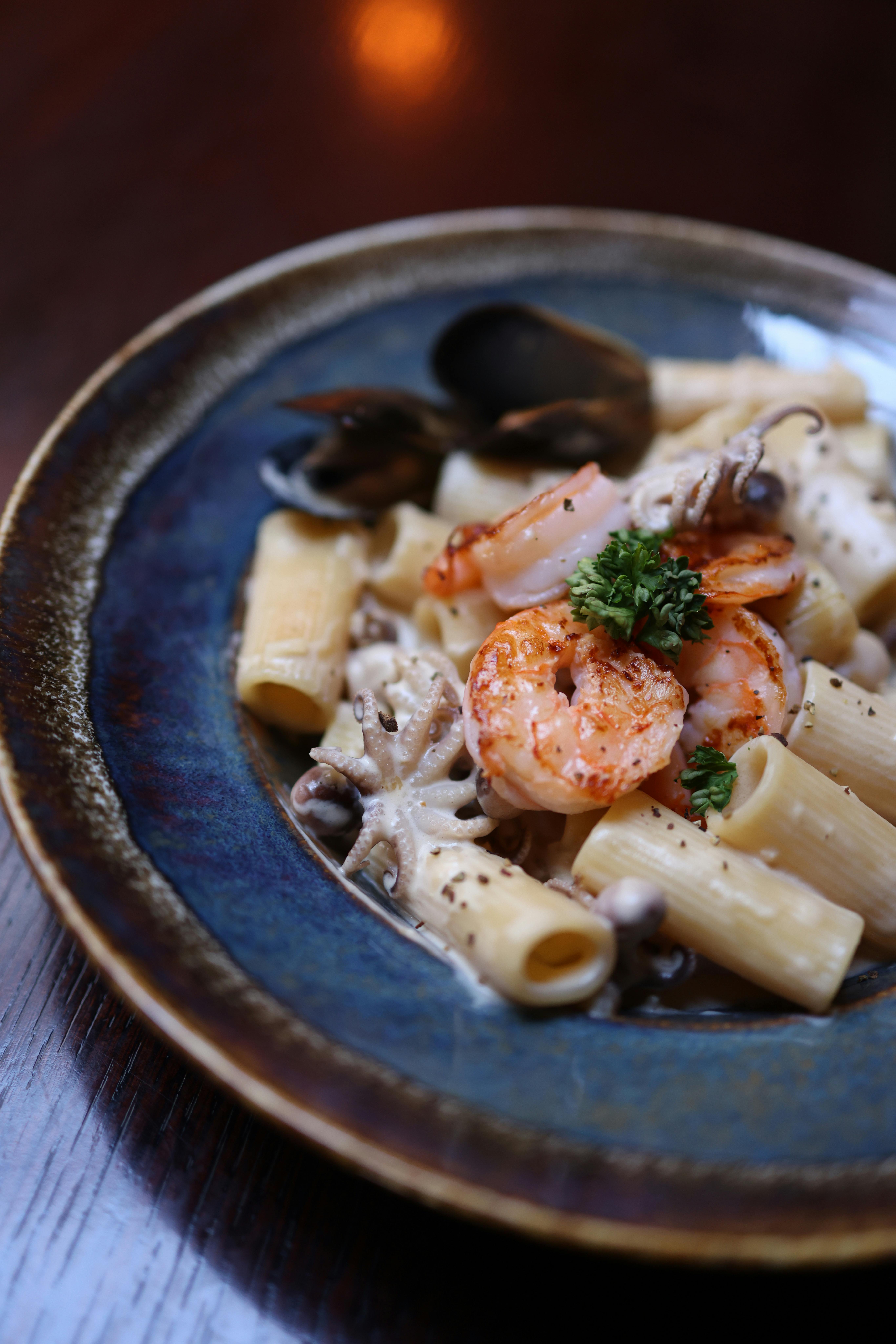 Gourmet presentation of shrimp rigatoni with herbs and cream sauce