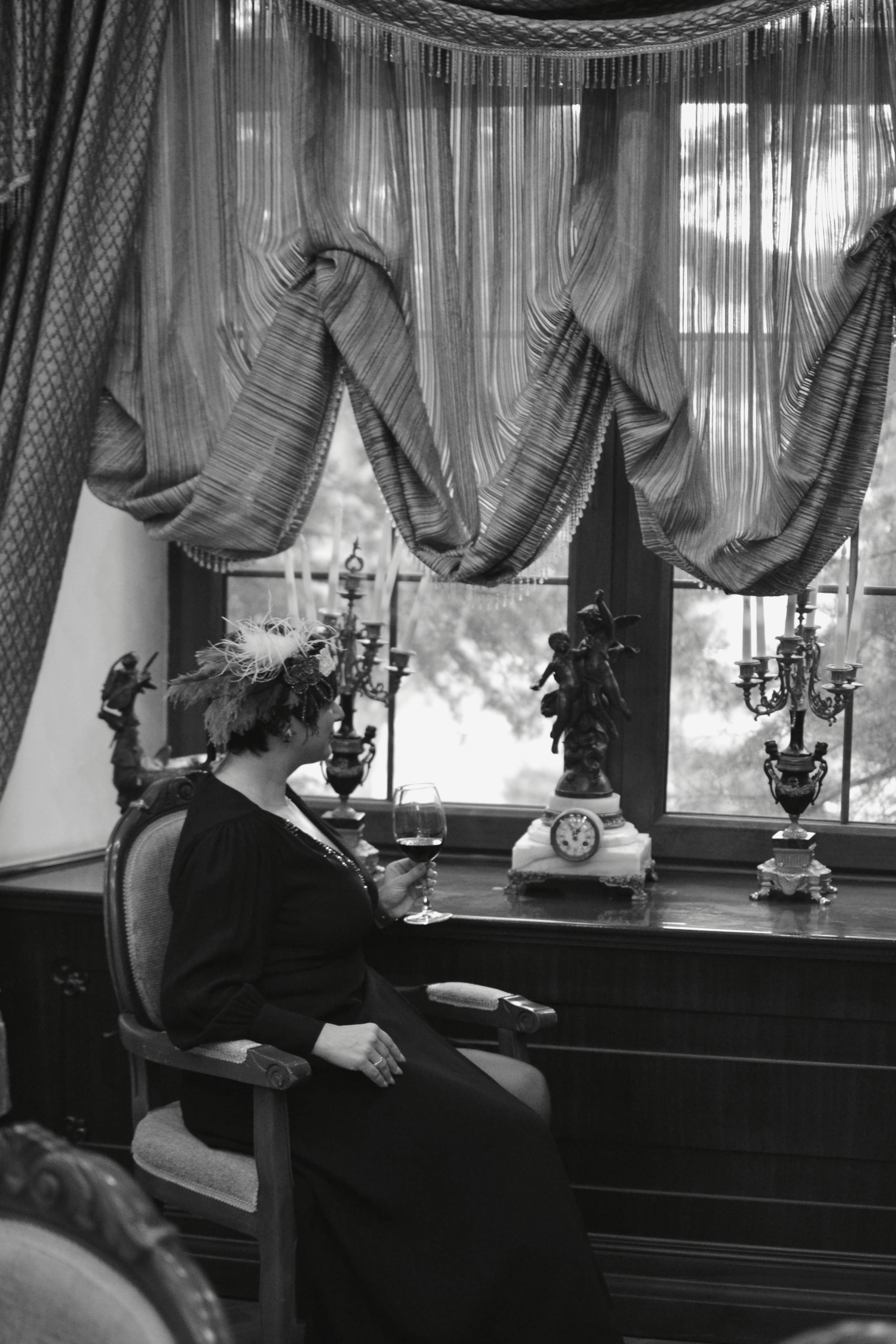 A woman in a classic interior setting, evoking vintage elegance in black and white.
