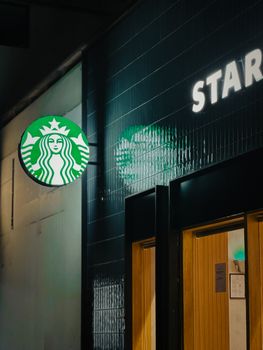 Illuminated Starbucks sign and entrance at night, showcasing cafe culture. 31236798