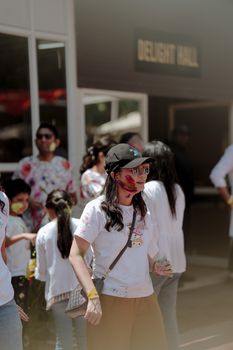 A vibrant outdoor Holi celebration with people enjoying colorful powders and festive atmosphere.