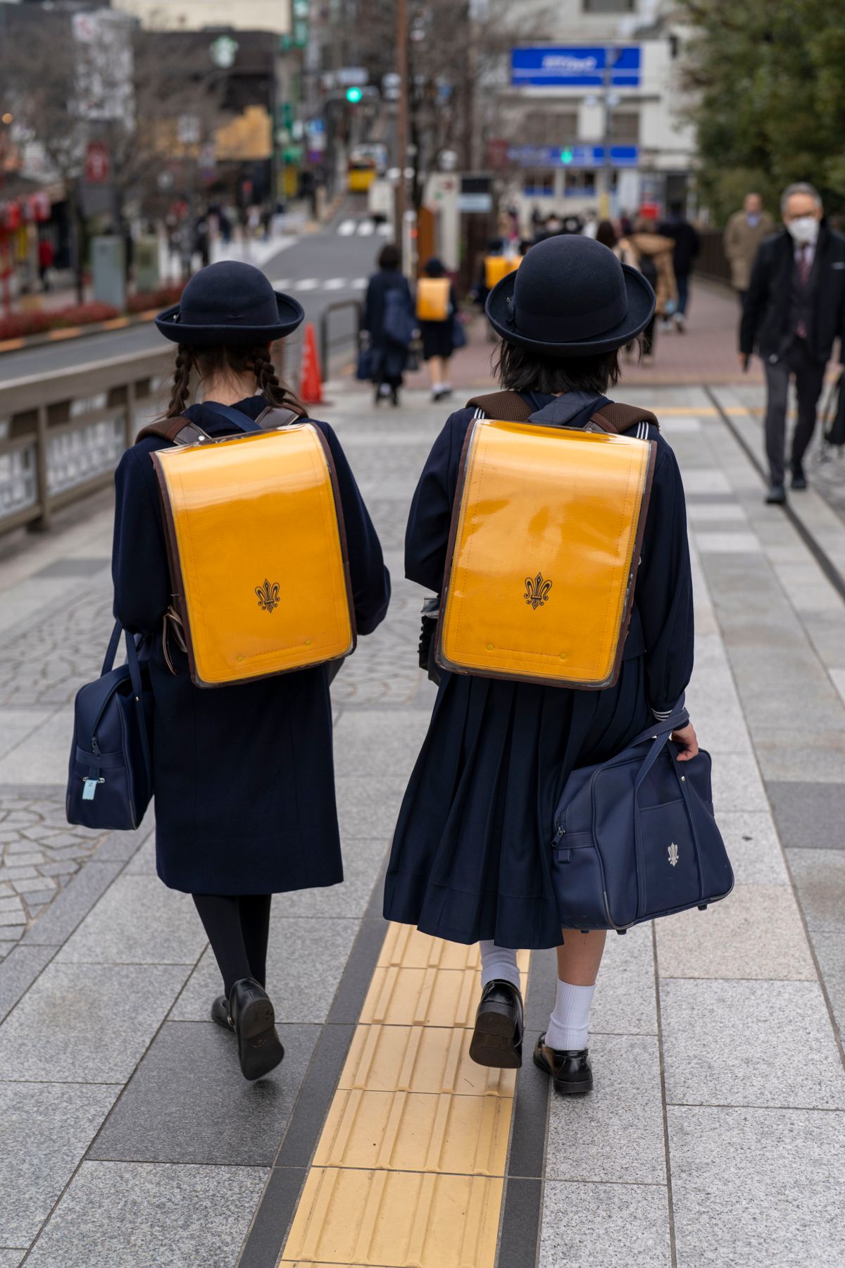 制服姿で登校する日本の生徒たちの後ろ姿