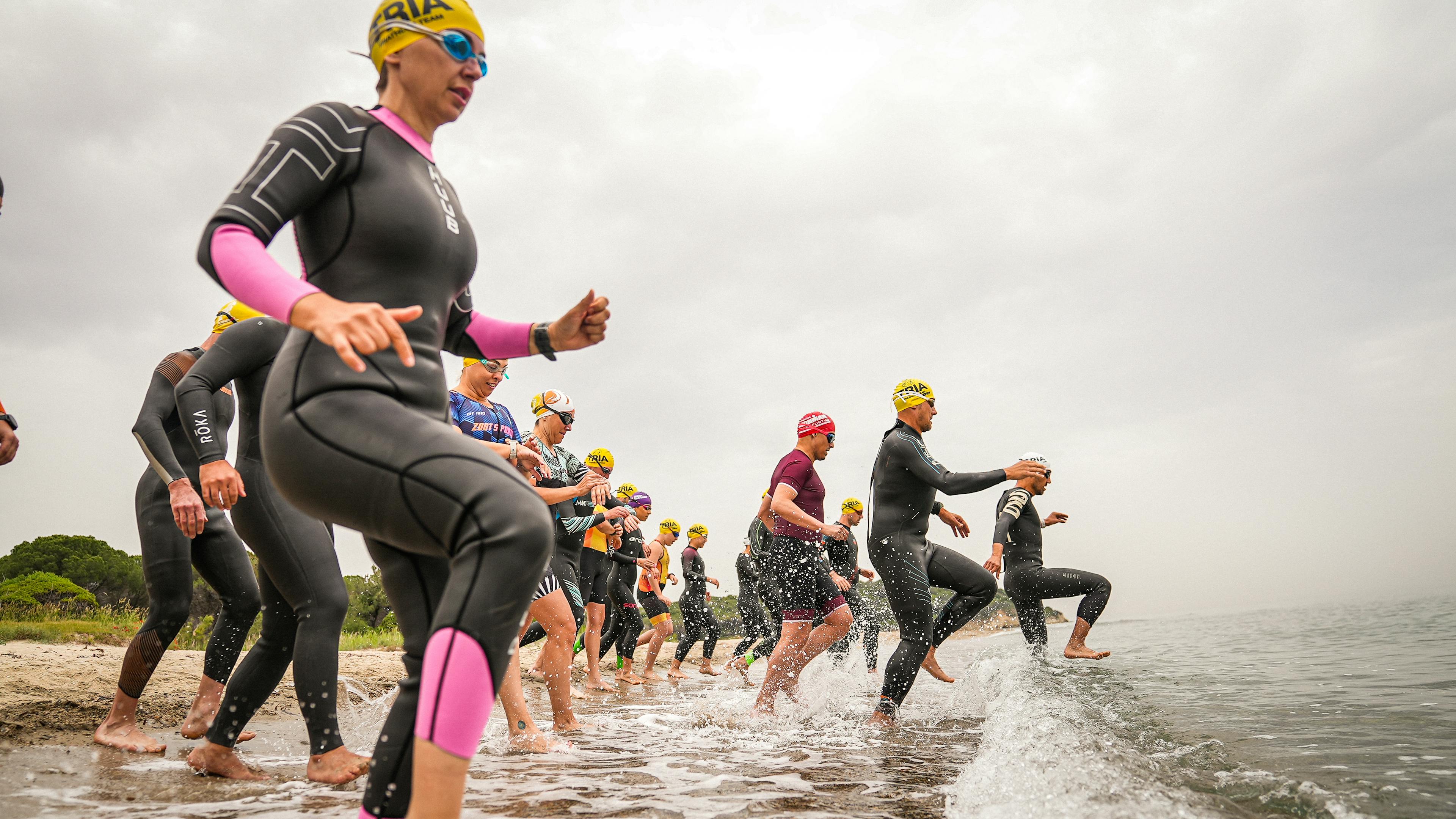 madame qui rentre dans l'eau pour faire la portion natation d'un premier triathlon