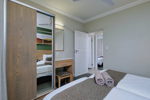 A modern and cozy bedroom interior with neatly arranged decor and furniture for a peaceful ambiance.