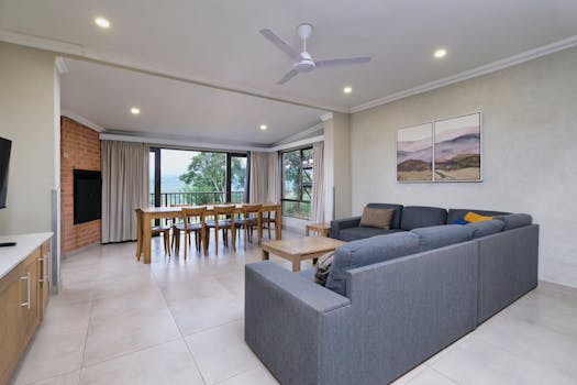 Bright and open modern living room with a view of nature through large windows.