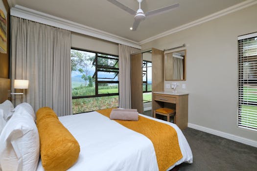 A beautifully designed bedroom with a natural view and modern furnishings.
