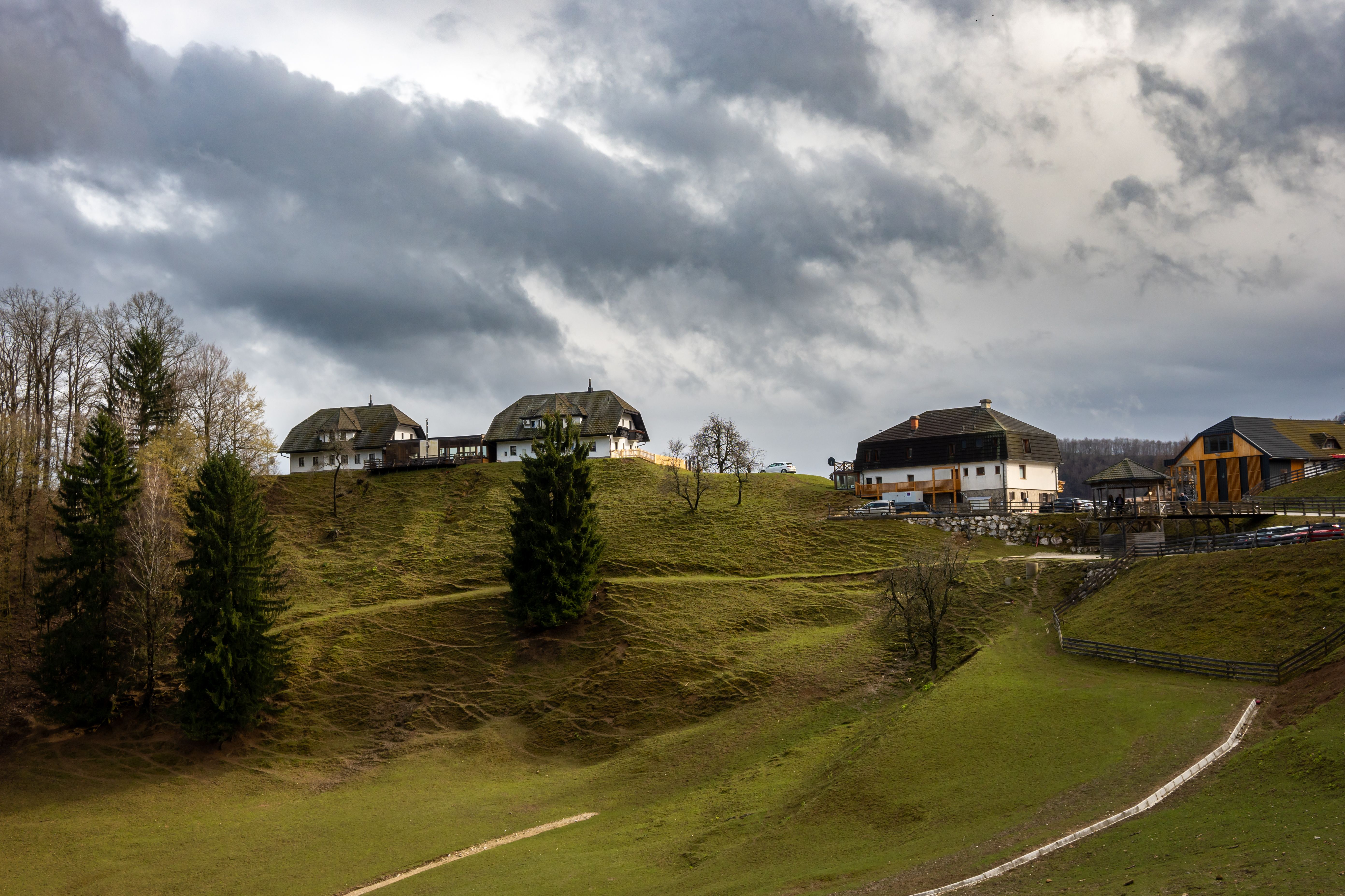 Charming hillside village scene in Šmarje pri Jelšah, Slovenia with dramatic clouds.