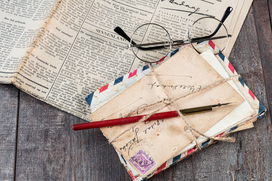 Free Eyeglasses on Newspaper Beside Mail Envelops Stock Photo