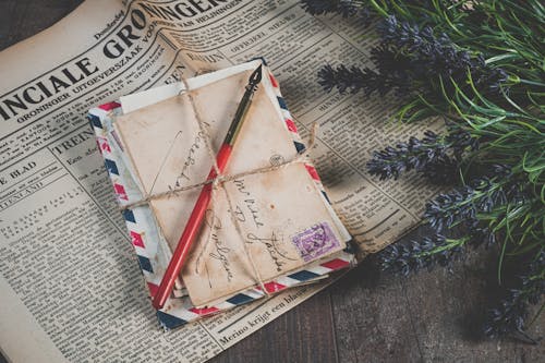 Free Shallow Focus Photo of Mail Envelope on Newspaper Stock Photo