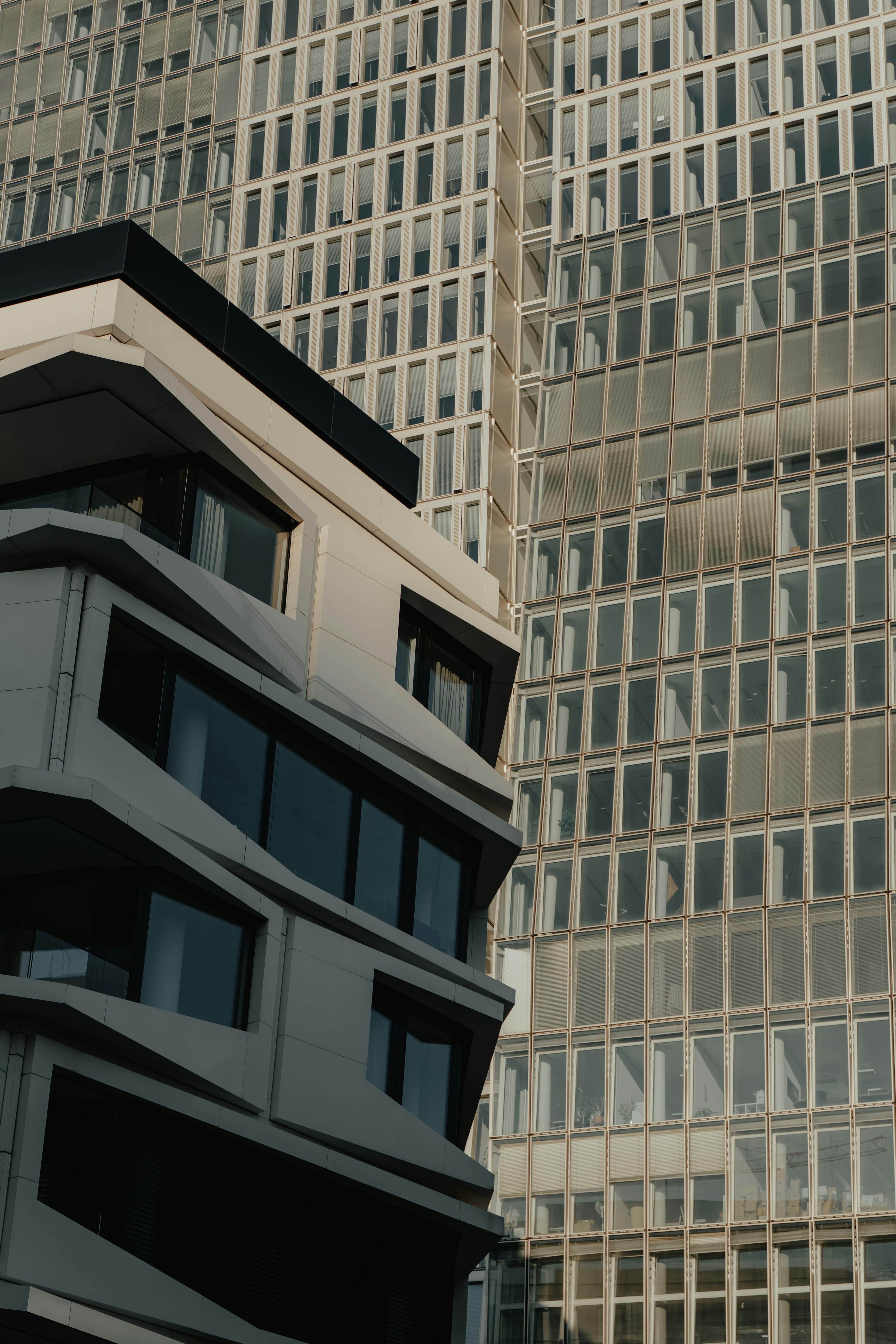 Close-up view of modern urban buildings with glass facades showcasing architectural contrast and design.
