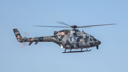 Free A military helicopter in flight at Aero India, Bengaluru, clear blue sky. Stock Photo