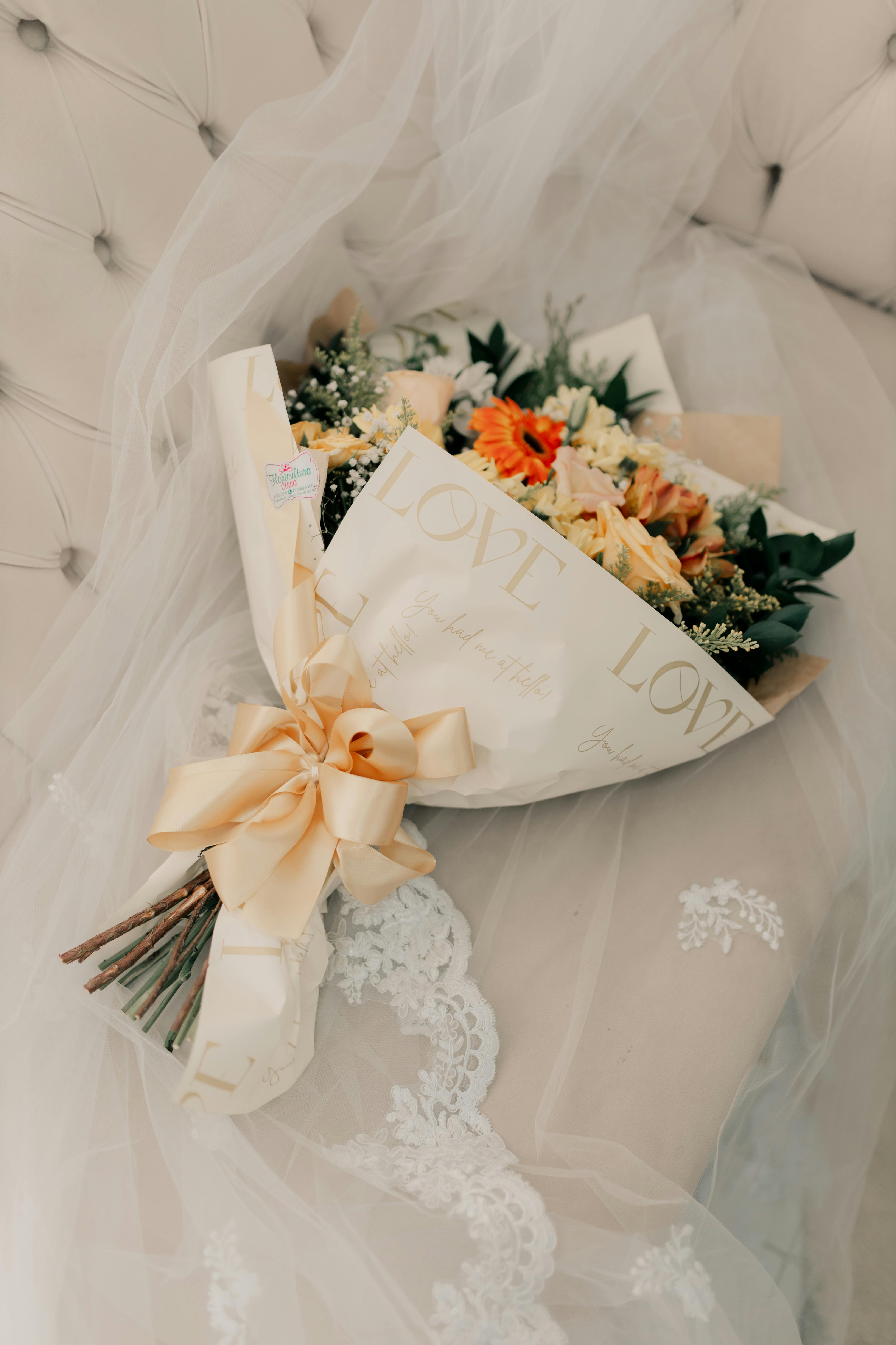 Beautiful floral wedding bouquet with 'love' wrapping on delicate lace.