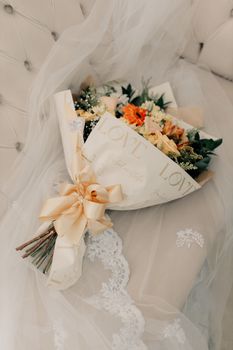 Beautiful floral wedding bouquet with 'love' wrapping on delicate lace.
