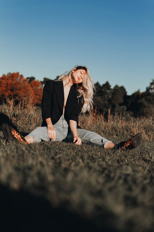 Photo Of Woman Sitting On Grass Field