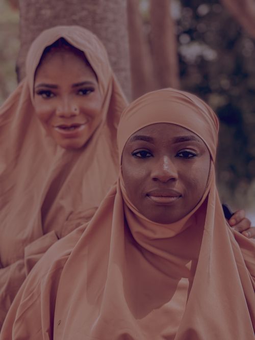 Free Two women in neutral-toned hijabs pose outdoors, conveying serenity and culture. Stock Photo