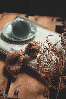 茶杯和茶托放在书上，配有粗麻布蝴蝶结，非常适合舒适的室内设计