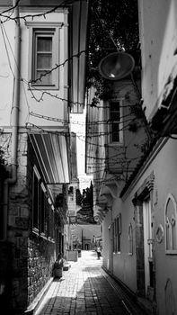Captivating black and white photo of a narrow alley with old buildings and rustic charm.