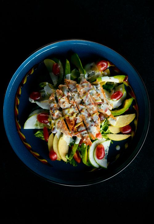 Free Fresh grilled chicken salad with vegetables and dressing on a blue ceramic plate. Stock Photo