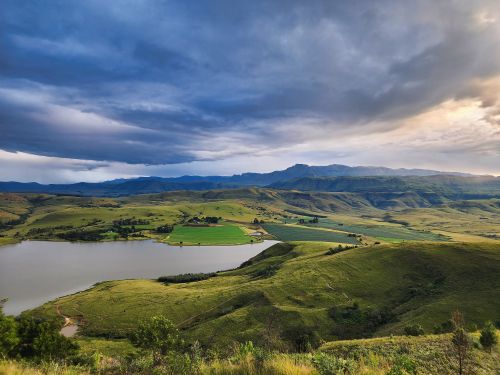 Free A stunning view of the lush Drakensberg mountains and valley under a dramatic sky. Stock Photo