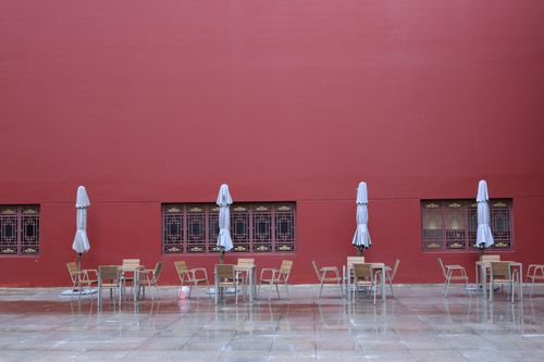 Free Peaceful outdoor seating area in Kunming, Yunnan, China, against a striking red wall. Stock Photo
