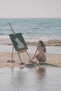 Woman painting by the beach, capturing the serene essence of art and nature.