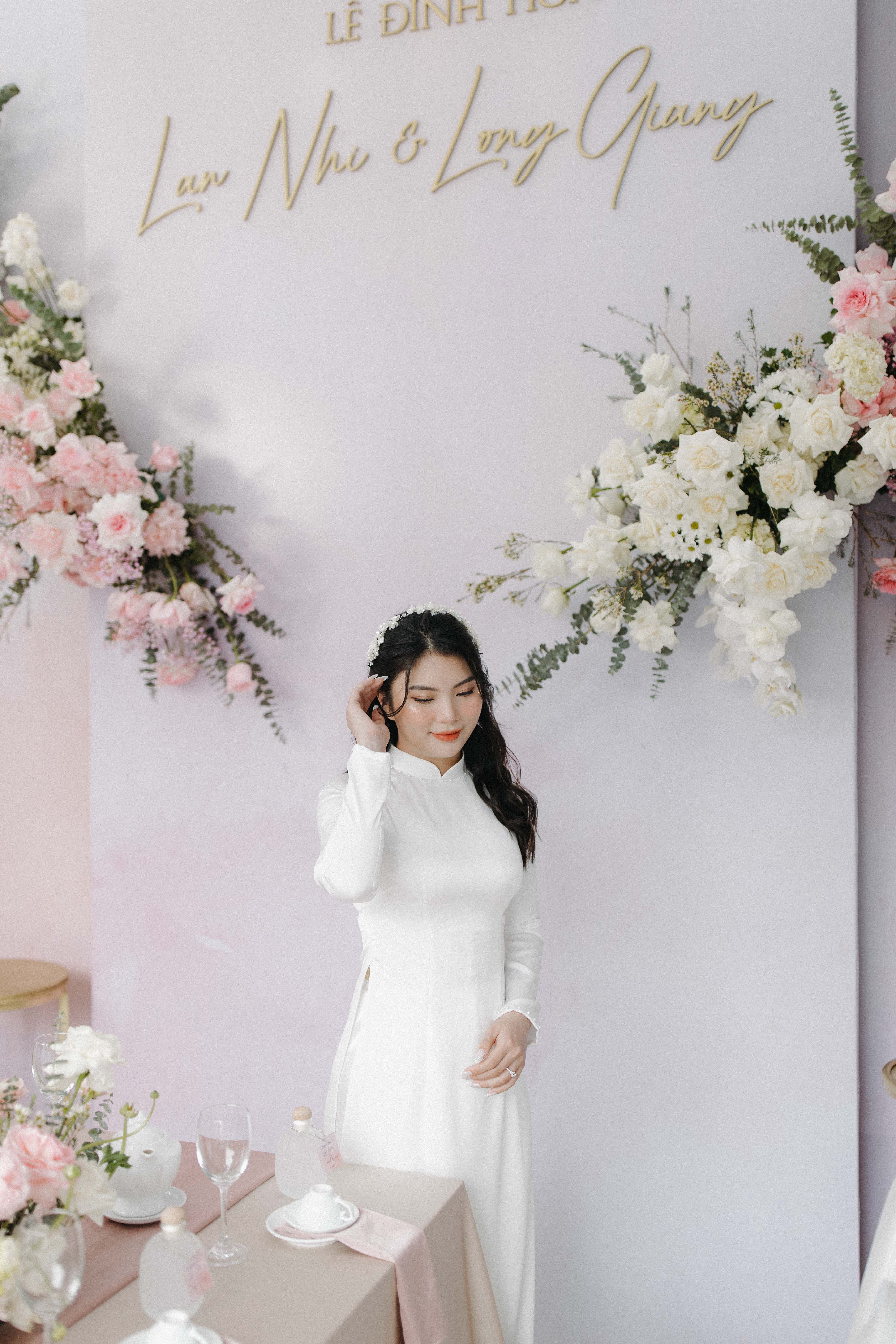 Beautiful woman in traditional Ao Dai with floral arrangement, perfect for weddings and celebrations.