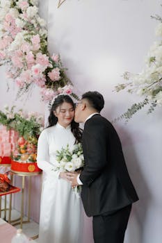 Elegant wedding scene featuring an Asian couple in traditional attire with floral decor.