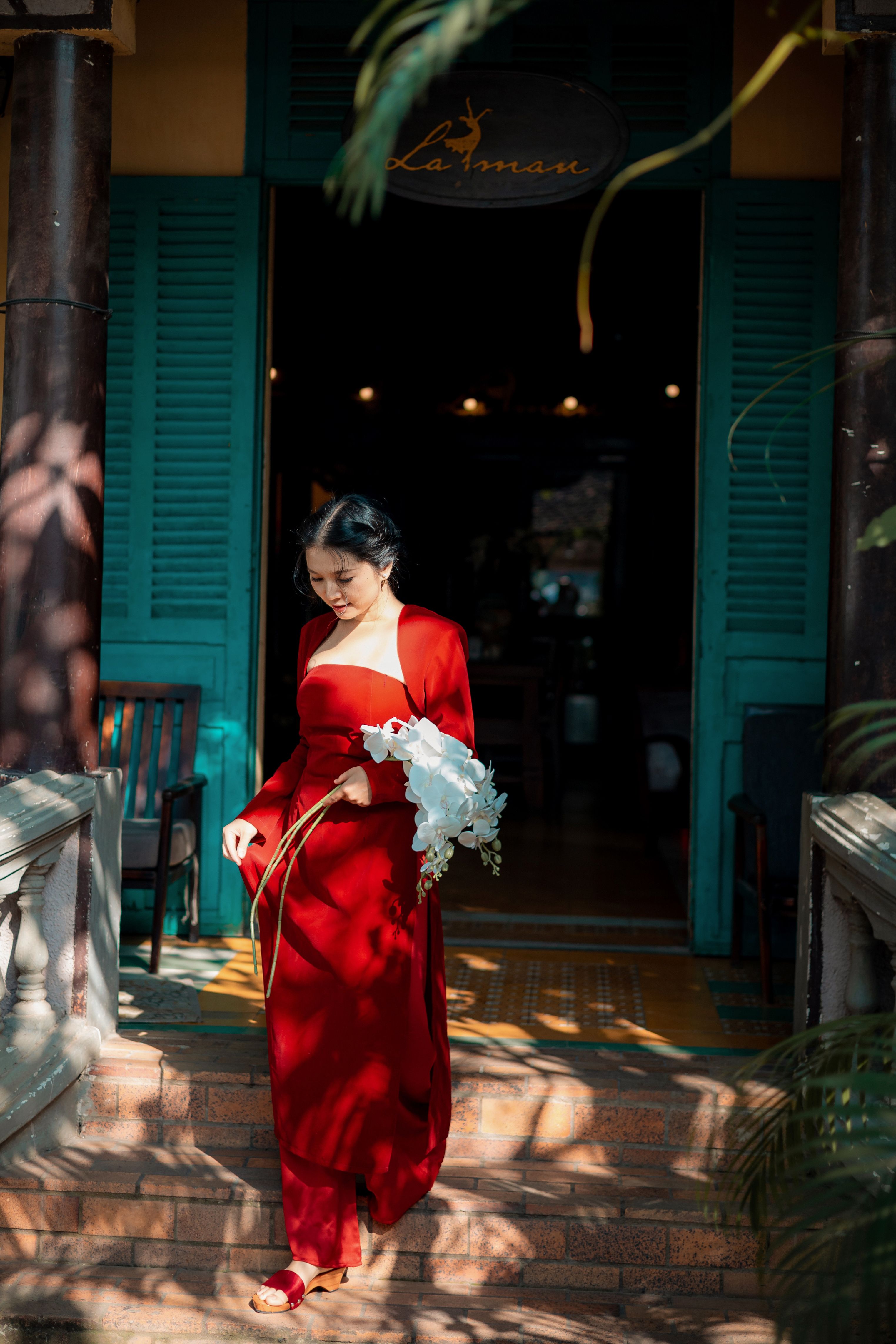Elegant Woman in Red Dress Holding Flowers · Free Stock Photo