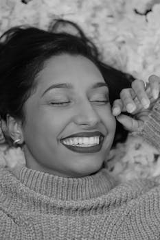 Close-up portrait of a smiling woman in a studio setting, expressing joy and warmth.