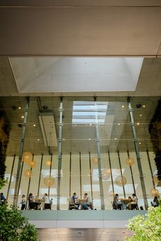 Contemporary office space with large skylight and natural lighting through glass walls.