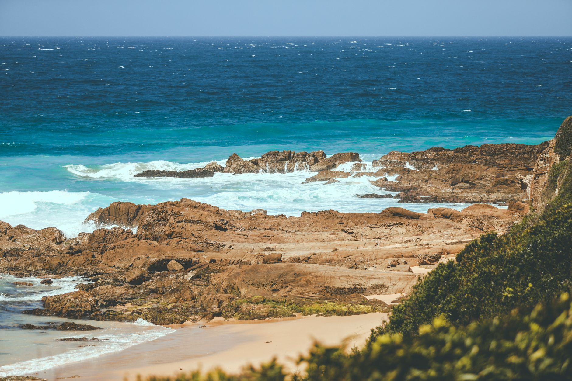 Explore the rugged beauty of Australia's rocky coastline with clear turquoise waters.