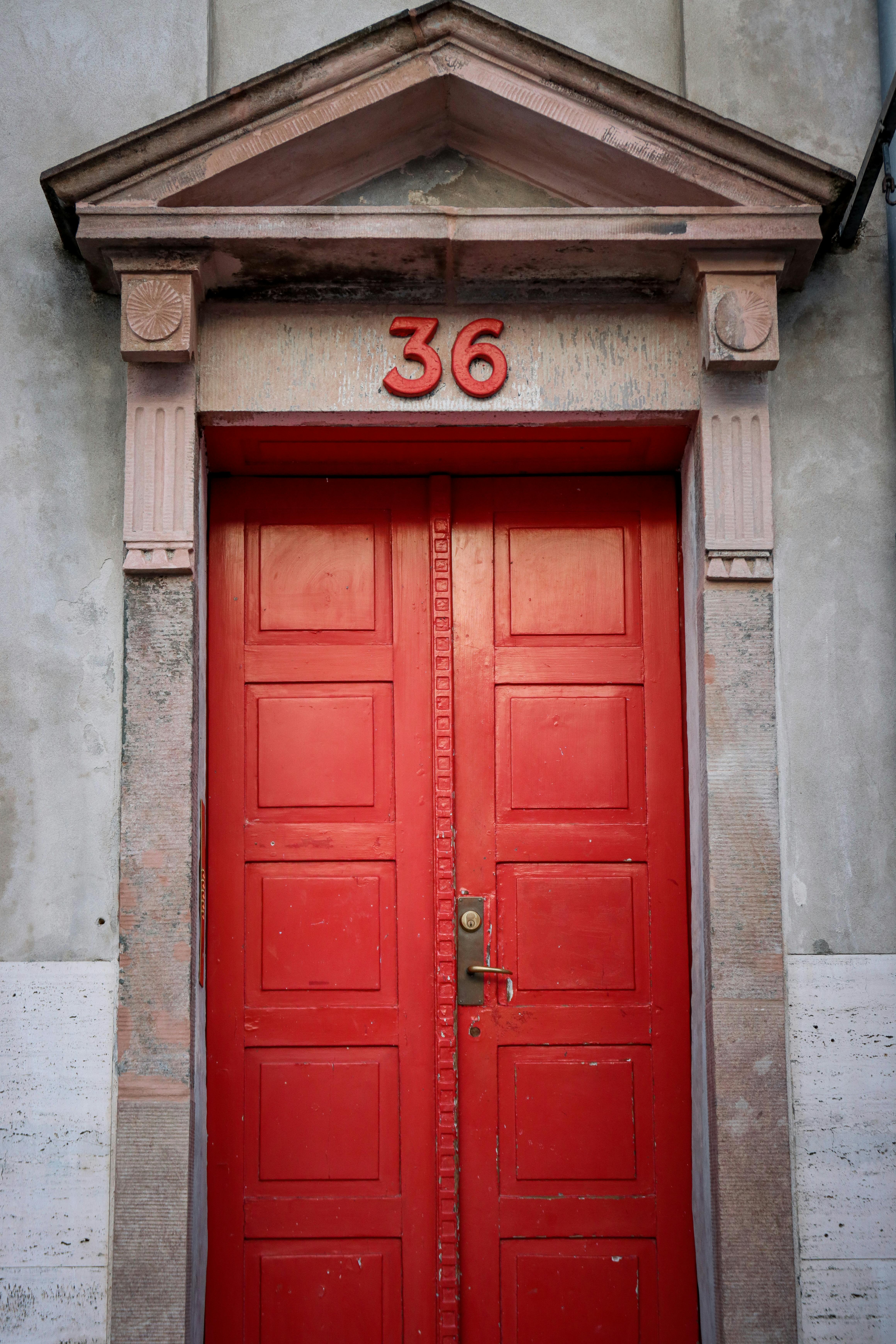 Bright red door with number 36 in historic architecture in Copenhagen.