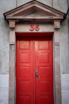 Bright red door with number 36 in historic architecture in Copenhagen.